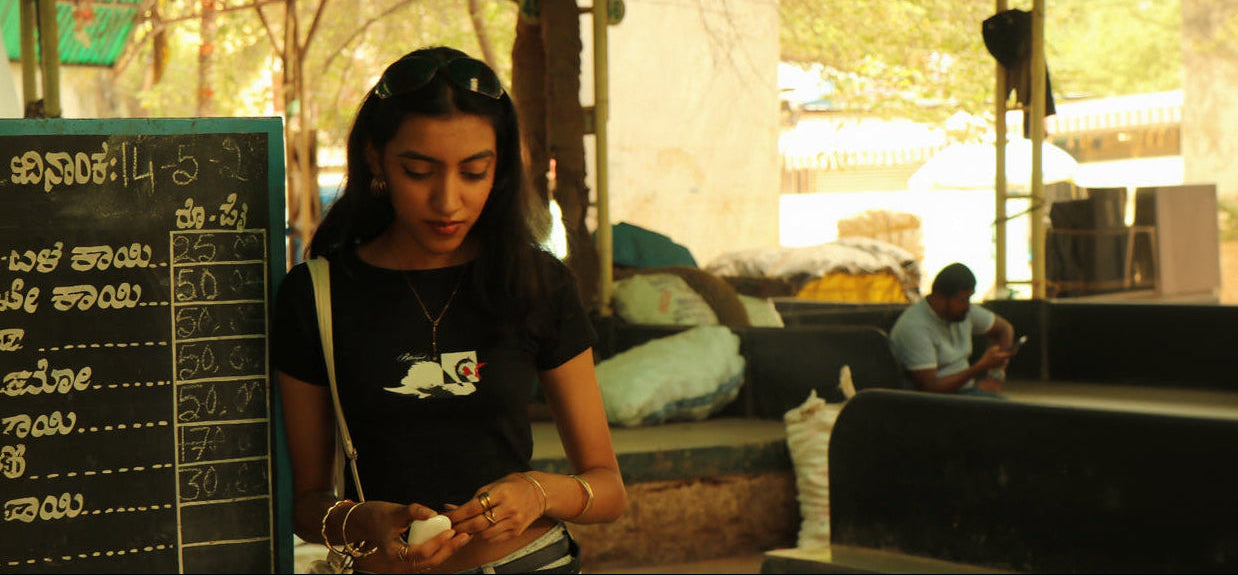Woman using a phone in a casual setting with a menu board on the left